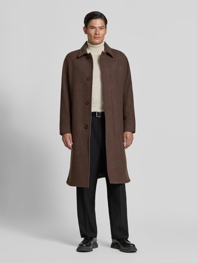 Männermodel trägt Mantel aus Woll-Mix mit seitlichen Eingrifftaschen von Tiger of Sweden, braune Farbe, glatte Textur, Ganzkörperansicht von vorne. Straight Fit, Kentkragen und Knopfleiste sind sichtbar, Rückenlänge 115 cm, Schulterbreite 51 cm, Brustweite 59 cm, Ärmellänge 68 cm.