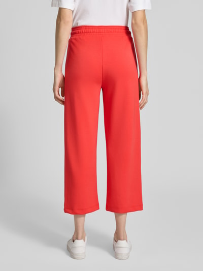 Frauenmodel trägt Wide Fit Sweatpants in verkürzter Passform Modell 'Banu' von Soyaconcept im Elastischer-Material-Mix, Ganzkörperansicht Rückansicht.