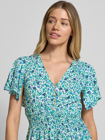 Frauenmodel trägt Knielanges Kleid aus Viskose von Apricot im Allover-Look mit V-Ausschnitt, Knopfleiste, taillierter Schnitt, Nahaufnahme Oberkörper.