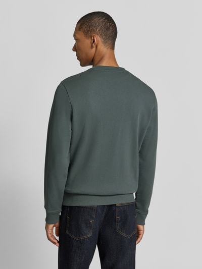 Mannenmodel draagt Sweatshirt met Label-Stitching model 'BALIS' van Napapijri in donkergroen, regular fit, katoen, rugaanzicht, context: heren sweatshirt, ronde hals, ruglengte maat M 68 cm, mouwlengte maat M 69 cm. Ganzichtrugaanzicht.