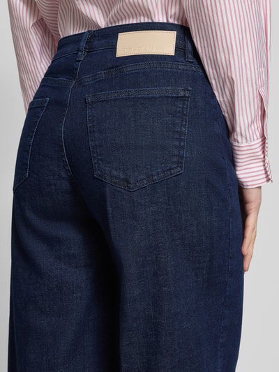 Kobieta nosi granatowe Wide Leg Jeans z kantami model 'Miva Authentic' od OPUS z bawełny, widoczne naszywane kieszenie, zbliżenie na tył