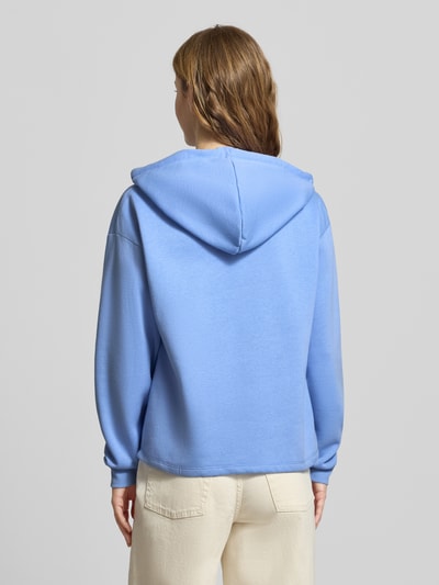 Modelka kobieca nosi Regular Fit Hoodie aus Baumwoll-Mix Modell 'CHILLI' od Pieces, jednokolorowy niebieski, długi rękaw, bawełniany sweat, widok całej sylwetki od tyłu.