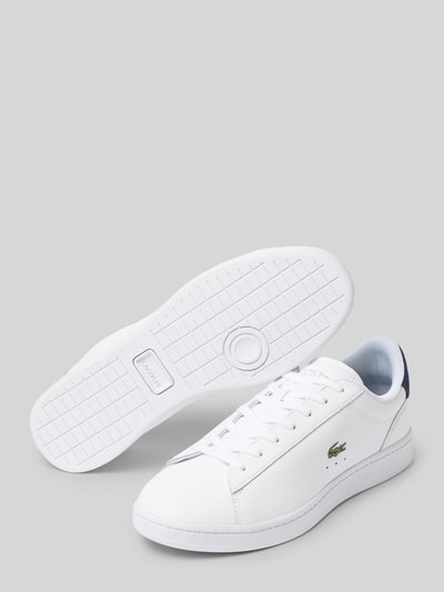 Produktfoto, weißer Sneaker aus echtem Leder Modell von Lacoste für Herren, glatte Oberfläche, grüne Logo-Stickerei, grauer Hintergrund