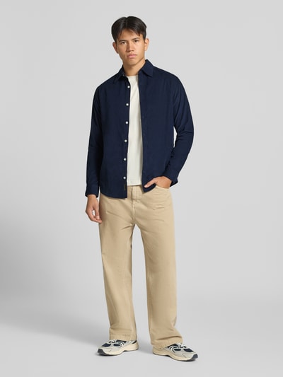 Männermodel trägt Slim Fit Freizeithemd aus Cord mit Kentkragen von JACK & JONES in Dunkelblau, beige Hose, Ganzkörperansicht von vorne. Kontext: Reine Baumwolle, Knopfleiste, Rückenlänge 75 cm, Schulterbreite 42 cm, Ärmellänge 64 cm.