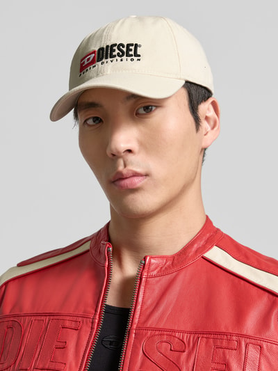 Männermodel trägt Basecap mit Label-Stitching von Diesel aus reiner Baumwolle, verstärkter Schirm, verstellbarer Verschluss, Nahaufnahme Oberkörper.