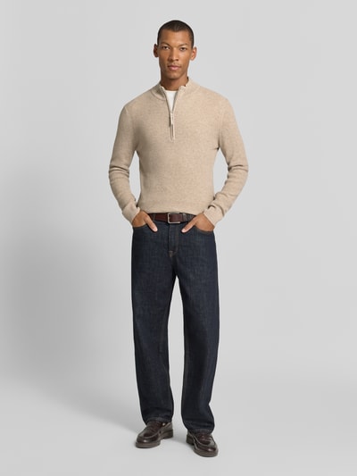 Męski model nosi Troyer aus Woll-Cashmere-Mix Modell 'Steffen' od BRAX, beżowy sweter w jednolitym kolorze, tekstura dzianiny, długi rękaw, kołnierz troyer z zamkiem, widok całej sylwetki z przodu.