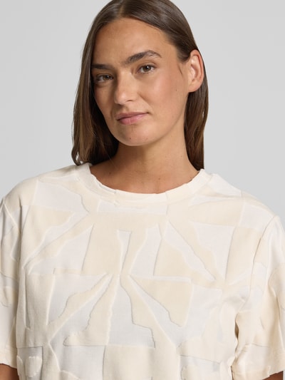 Frauenmodel trägt T-Shirt im Allover-Look Modell 'NABI' von ICHI, cremefarbene und weiße Flächen, Baumwoll-Mix, Nahaufnahme Oberkörper.