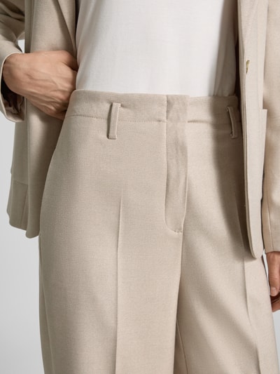 Frauenmodel trägt Wide Fit Hose mit Viskose-Anteil von MORE & MORE in Beige, Bundfalten, feine Textur, Nahaufnahme Oberkörper.