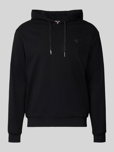 Männermodel trägt Regular Fit Hoodie in Strick-Optik von Antony Morato, schwarz, Kapuze, Baumwoll-Mix, Ganzkörperansicht von vorne.
