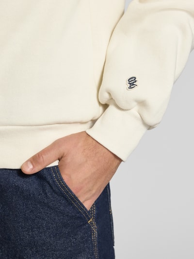 Männermodel trägt Sweatshirt mit Label-Print Modell 'FREDERIKSBERG' von JACK & JONES, cremefarbener Baumwoll-Mix, Nahaufnahme Oberkörper.