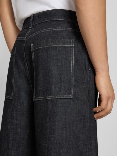 Mężczyznamodel nosi Extra Baggy Fit bermudy model LLOYD od Jack & Jones, czarna bawełna, wpuszczane kieszenie, szerokość w rozmiarze M: 41 cm, długość wewnętrzna nogawki w rozmiarze M: 30 cm, detal z tyłu, zbliżenie na tylną kieszeń.