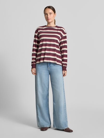 Frauenmodel trägt Regular Fit T-Shirt aus reiner Baumwolle von Jake*s Casual in Burgunderrot mit weißen Streifen, weite Jeans, Ganzkörperansicht von vorne.