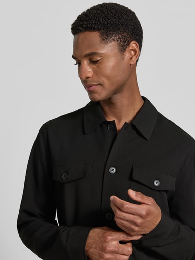 Männermodel trägt Relaxed Fit Hemdjacke mit Brusttaschen von Lindbergh aus Material-Mix mit Viskose-Anteil, Knopfleiste, Kentkragen, Nahaufnahme Oberkörper.