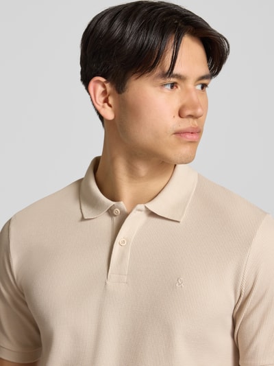 Männermodel trägt Regular Fit Poloshirt mit Strukturmuster Modell 'AUSTIN' von Jack & Jones in beige, met katoenmix, knoopsluiting, stitching, Nahaufnahme Oberkörper.