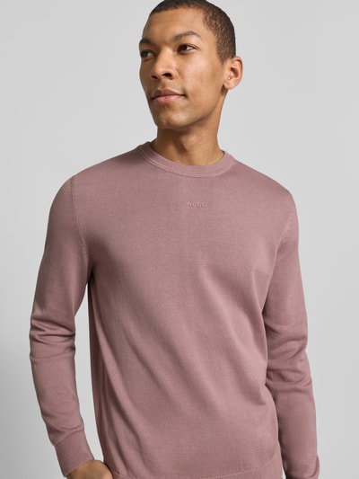 Męski model nosi Regular Fit Strickpullover aus reine Baumwolle Modell 'SAN CASSIUS-C2' od HUGO, jednolity kolor, krój regular fit, długi rękaw, ściągacze, dzianina, crew neck, nadruk z logo, widok na górną połowę ciała z przodu.