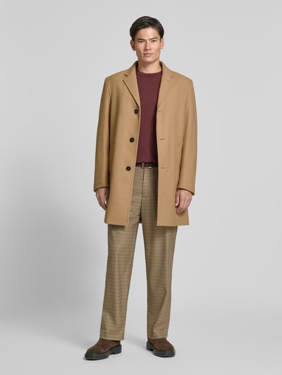 Männermodel trägt Regular Fit Mantel aus Woll-Mix von HECHTER PARIS in Beige, glatte Textur, Knopfleiste, Ganzkörperansicht von vorne. Rückenlänge 95 cm, Schulterbreite 43 cm, Brustweite 57 cm, Ärmellänge 67 cm.