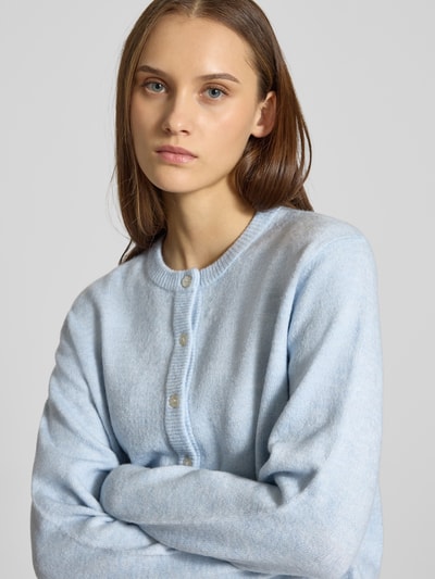 Vrouwenmodel draagt Regular fit gebreid jack met eenrijige knoopsluiting model 'SIMONI' van ONLY, look: effen, ronde hals, lange mouw, geribde boorden, knitwear; detailopname bovenlichaam.