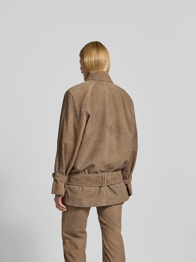Frauenmodel trägt Jacke aus echtem Ziegenvelours von Rotate in Taupe, Oversized Fit, Umlegekragen, Doppelknopfleiste, Eingrifftaschen, Rückansicht Ganzkörperansicht.