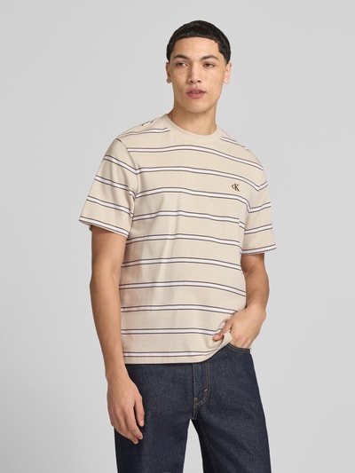 Männermodel trägt T-Shirt mit Logo-Stitching von Calvin Klein Jeans, Reine Baumwolle, Gerader-Schnitt, Rundhalsausschnitt, Rückenlänge 69 cm, Ganzkörperansicht von vorne.