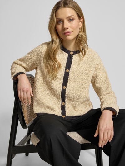 Frauenmodel trägt Strickjacke mit Knopfleiste Modell 'BESSIE' von Soyaconcept, beige mit schwarzen Akzenten, Regular Fit, Ganzkörperansicht von vorne.