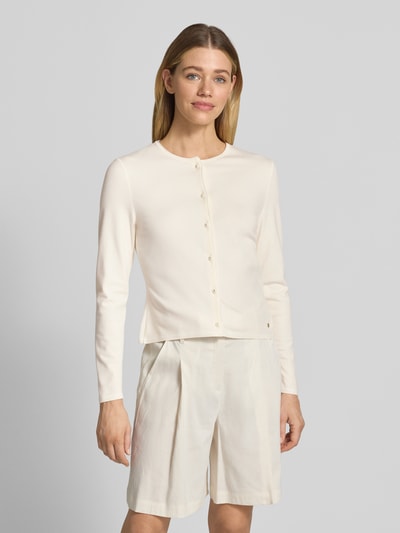 Frauenmodel trägt Cardigan aus Viskose-Mix mit Kontrastkante von Marc Cain in Creme, gerade geschnitten, Knopfleiste, Nahaufnahme Oberkörper.