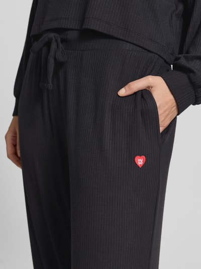 Vrouwenmodel draagt zwarte Relaxed Fit Sweathose uit modalmix model 'HUGO HEART' van HUGO, Dames, detailopname heupzone