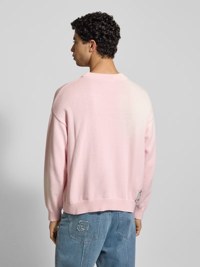 Männermodel trägt Strickpullover mit gerippten Abschlüssen von ANOTHER COTTON LAB in Hellrosa, Reine Baumwolle, Lockerer-Schnitt, Ganzkörperansicht Rückansicht.