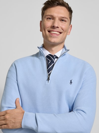 Männermodel trägt Regular Fit Troyer aus reiner katoen van Polo Ralph Lauren in effen lichtblauw piqué met logodetail, korte ritssluiting, lange mouw met geribde mouwboord, rompzoom geribd, Nahaufnahme Oberkörper.