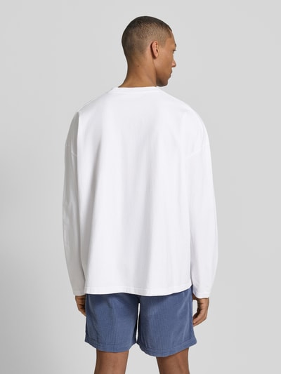 Männermodel trägt Longsleeve mit Logo-Print Modell 'GIXY' von American Vintage aus Reine Baumwolle, weiß, Loose-Fit, Rückenansicht.