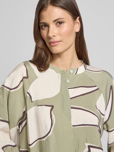 Modelka kobieca nosi Bluzę z okrągłym dekoltem model 'Faloom' od OPUS, modalowy mix, krój loose fit, 3/4 rękaw, zapięcie kryte, wzór abstrakcyjny w odcieniach zieleni i kremu, zdjęcie: zbliżenie na górną część sylwetki.
