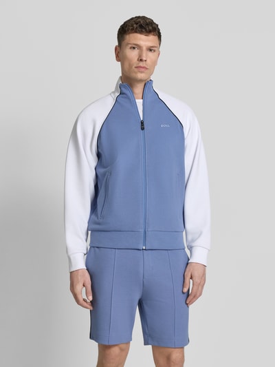 Mannenmodel draagt Regular Fit sweatjack uit katoenmix model 'JOIN SKAZ' van BOSS in tweekleurige look, piqué sweat, steekzakken, ritssluiting, opstaande kraag, lange mouwen met geribd mouwboord, labelstitching applicatie; voorkant, bovenlichaam close-up.