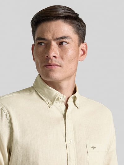 Männermodel trägt Slim Fit Freizeithemd aus Leinen-Baumwoll-Mix von Fynch-Hatton, heller Stoff, Label-Stitching, Nahaufnahme Oberkörper.