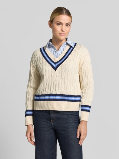 Frauenmodel trägt Regular Fit Pullover aus reiner Baumwolle von MANGO in Strick-Optik, V-Ausschnitt, creme mit blauen Streifen, Ganzkörperansicht von vorne.