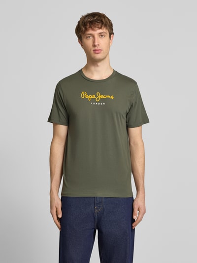 Männermodel trägt Herren T-Shirt von Pepe Jeans, Modell 'EGGO', Optik: Unifarben, Regular-Fit, Rundhals, Kurzarm, reine Baumwolle, Label-Print auf der Brust, Jersey-Textur, Ganzkörperansicht von vorne.