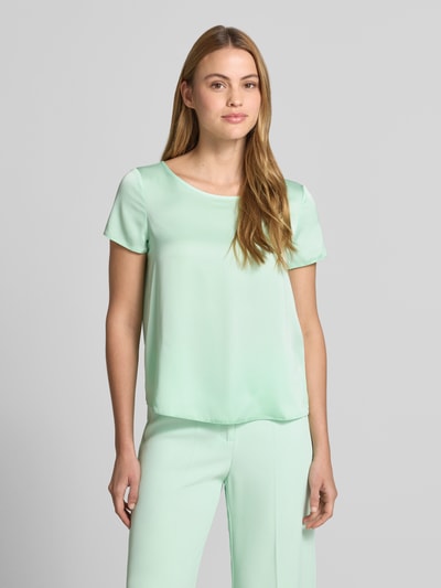 Frauenmodel trägt Blusenshirt mit Rundhalsausschnitt und abgerundetem Saum von Rinascimento in Pastellgrün, Material-Mix, Loose Fit, Ganzkörperansicht von vorne.