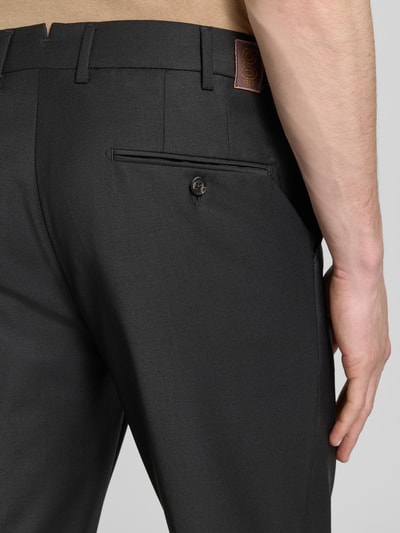 Mężczyzna nosi Straight Fit Stoffhose mit Woll-Anteil od g1920, elastyczna mieszanka materiałów, wpuszczane kieszenie, guzik z tyłu, detal z logo, długość wewnętrzna nogawki 80 cm w rozmiarze 32/32, szerokość w rozmiarze 32/32: 46 cm, zakładki w pasie, zapięcie na haftkę i zamek błyskawiczny, widok z tyłu, zbliżenie na biodro