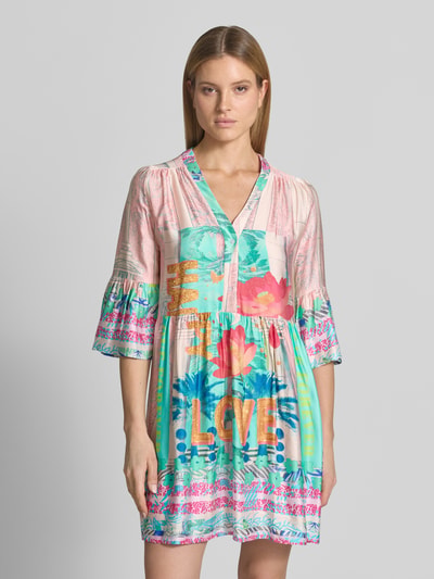 Modelka kobieca nosi Relaxed Fit Minikleid aus reiner Viskose Modell 'Love' od miss goodlife, wzór kwiatowy, półdługie rękawy, dekolt V, kolorowy, miękka tekstura, długość tyłu w rozmiarze S: 88 cm, szerokość w rozmiarze S: 50 cm, długość rękawa w rozmiarze S: 47 cm, przód, zbliżenie na górną część ciała.