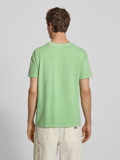 Männermodel trägt T-Shirt aus Baumwoll-Leinen-Mix mit Brusttasche von Superdry in Hellgrün, Regular-Fit, Rückenlänge 66 cm, Ganzkörperansicht Rückansicht.
