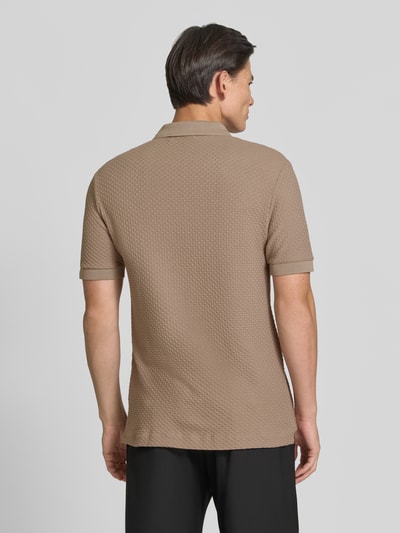 Männermodel trägt Regular Fit Poloshirt aus reiner Baumwolle Modell 'Parlay 82' von BOSS, sandfarben mit strukturierter Oberfläche, Ganzkörperansicht Rückansicht. Herren Poloshirt von BOSS.