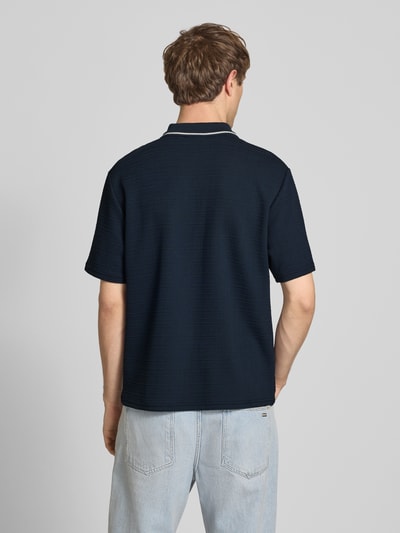 Männermodel trägt Regular Fit Poloshirt mit Reißverschluss und Label-Stitching von REVIEW, dunkelblau, Strukturmuster, Ganzkörperansicht Rückansicht