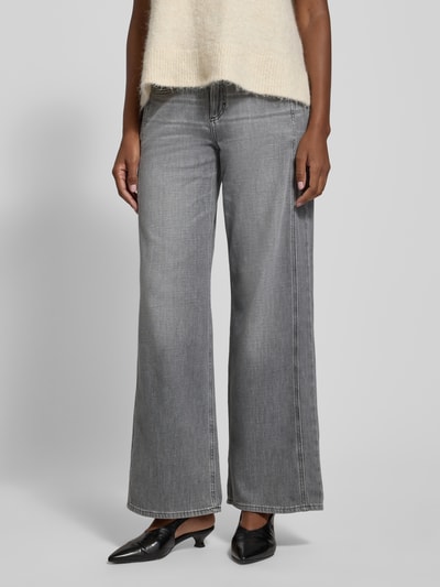 Kobiece model prezentuje szare spodnie Jeans mit weitem Bein Modell 'MORGAN' od Brax, bawełniano-elastanowa tkanina, szerokie nogawki, z przodu kieszenie, pełny przód sylwetki.