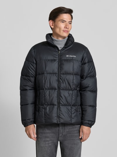 Männermodel trägt Regular Fit Jacke in Stepp-Optik Modell 'Puffect™' von Columbia in Schwarz mit Logo-Print, Ganzkörperansicht von vorne.