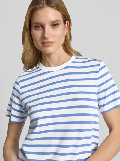Modelka kobieca nosi T-Shirt im Allover-Look mit Rundhalsausschnitt von comma z bawełny z domieszką elastanu, krój regular fit, pasiasty wzór, długość tyłu w rozmiarze 36: 57 cm, zbliżenie na górną część ciała.