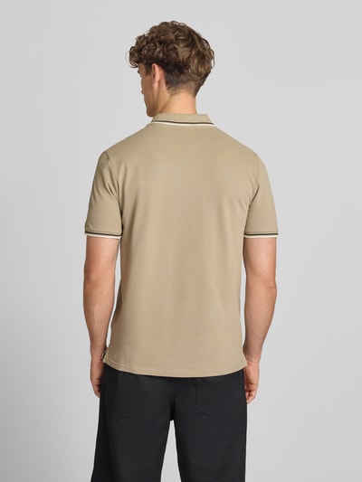 Männermodel trägt Slim Fit Poloshirt mit Label-Stitching von CHAMPION in Beige aus Reiner Baumwolle, Rückenansicht, Rückenlänge 73 cm bei Größe M.