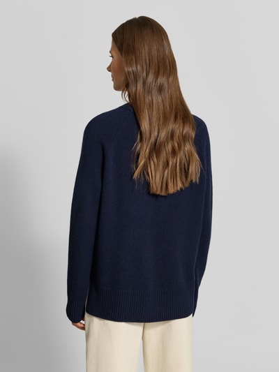 Frauenmodel trägt Regular Fit Pullover aus reinem Kaschmir in Strick-Optik von MYON, dunkelblau, weiche Textur, Rückenansicht, Ganzkörperansicht Rückansicht.