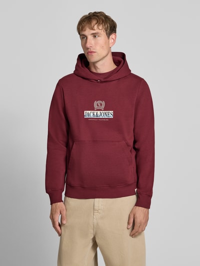 Männermodel trägt Hoodie mit Label-Print Modell 'FREDERIKSBERG' von JACK & JONES in Dunkelrot, Baumwoll-Mix, Ganzkörperansicht von vorne.