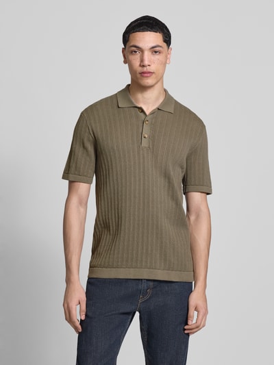 Männermodel trägt Regular Fit Poloshirt aus Baumwoll-Mix Modell 'MOON' von Only & Sons in Strickoptik mit Strukturmuster, olivgrün, Polokragen, Knopfleiste, gerippte Abschlüsse, Ganzkörperansicht von vorne.