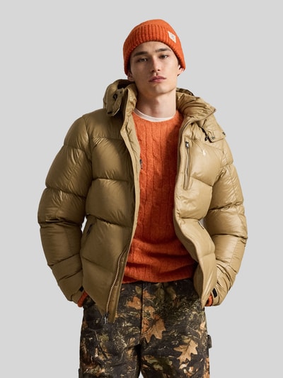 Männermodel trägt Regular Fit Steppjacke mit Zweiwege-Reißverschluss von Polo Ralph Lauren in Beige, orangefarbener Pullover, Ganzkörperansicht von vorne, Herren Steppjacke von Polo Ralph Lauren
