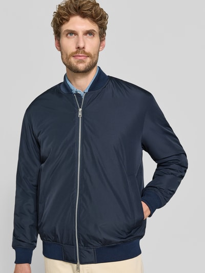 Männermodel trägt dunkelblaue Regular Fit Bomberjacke mit Baseball-Kragen Modell 'CHARLES' von Selected, Herren Bomberjacke, Nahaufnahme Oberkörper.