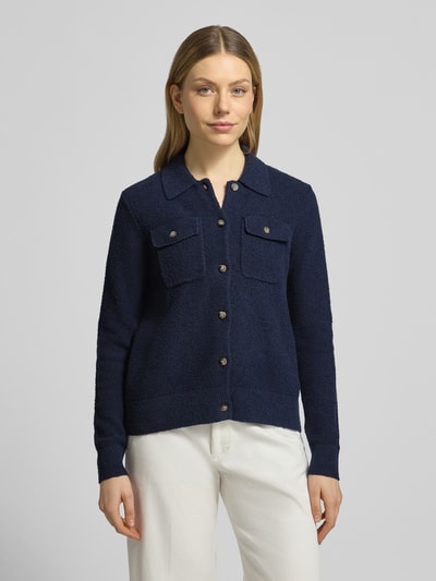 Frauenmodel trägt Regular Fit Jacke in Strick-Optik von Christian Berg Woman in Dunkelblau mit Brusttaschen und Umlegekragen, Ganzkörperansicht von vorne. Baumwoll-Mix, durchgehende Knopfleiste, elastische Abschlüsse, Rückenlänge 59 cm, Ärmellänge 65 cm bei Größe S.